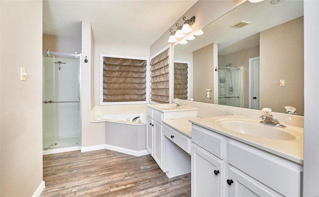 bathroom with vanity, hardwood / wood-style floors, and plus walk in shower