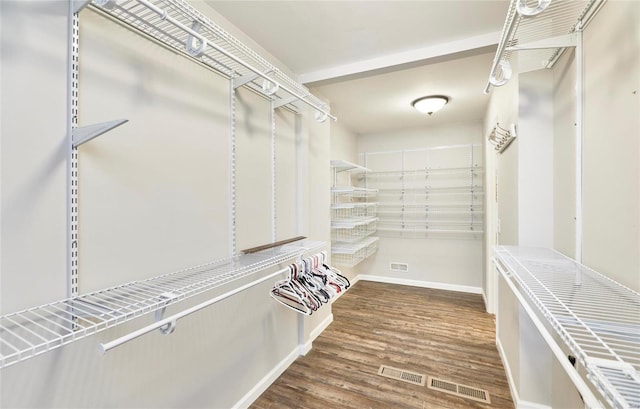 walk in closet with dark wood-type flooring