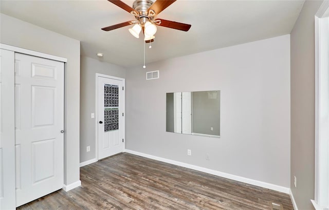 spare room featuring dark hardwood / wood-style flooring and ceiling fan