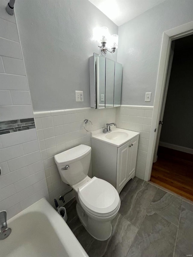 bathroom featuring vanity, a bathtub, toilet, and tile walls