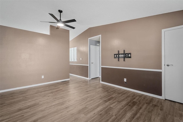 empty room featuring hardwood / wood-style flooring, ceiling fan, and lofted ceiling