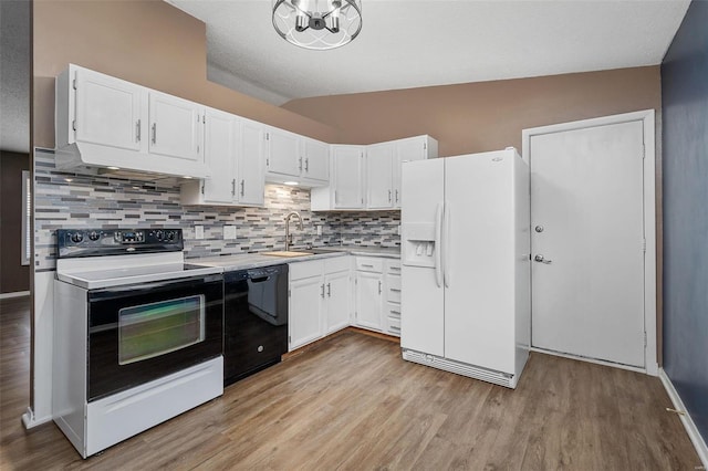 kitchen with backsplash, white appliances, vaulted ceiling, sink, and white cabinetry