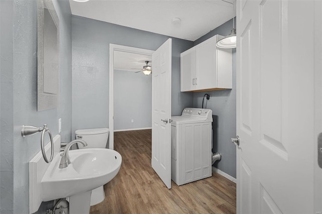 bathroom featuring sink, ceiling fan, toilet, washer / dryer, and wood-type flooring