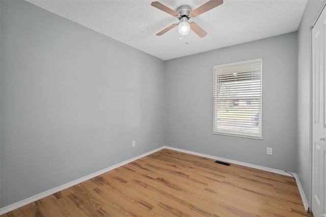 empty room with a textured ceiling, light hardwood / wood-style flooring, and ceiling fan