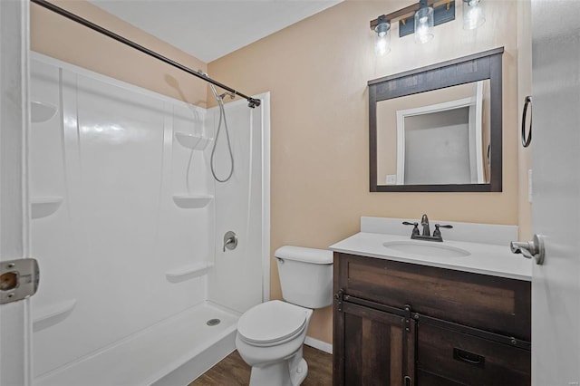 bathroom with vanity, hardwood / wood-style flooring, a shower, and toilet