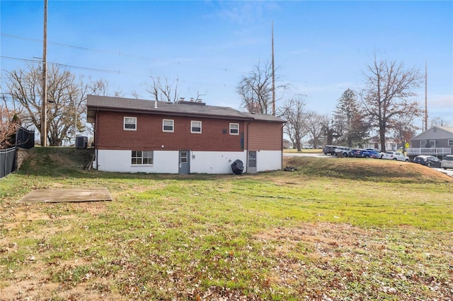 rear view of property with a lawn and cooling unit