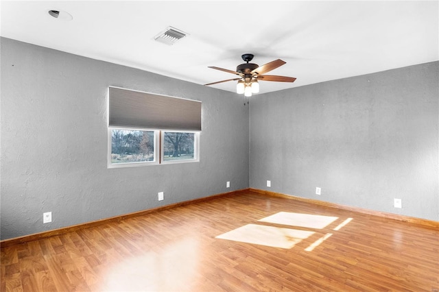 empty room with ceiling fan and hardwood / wood-style floors