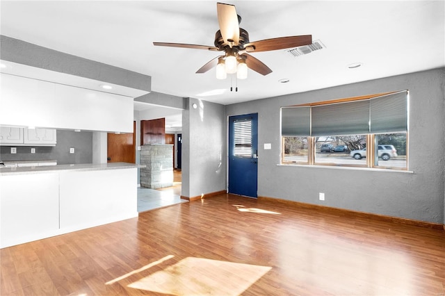 unfurnished living room featuring ceiling fan and light wood-type flooring