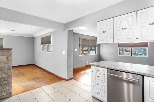 kitchen featuring white cabinets, stainless steel dishwasher, and light hardwood / wood-style flooring