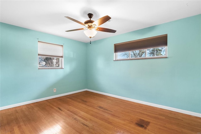 empty room featuring ceiling fan, wood-type flooring, and plenty of natural light