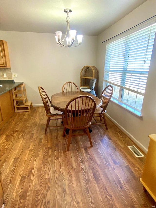 dining area featuring a notable chandelier and light hardwood / wood-style floors