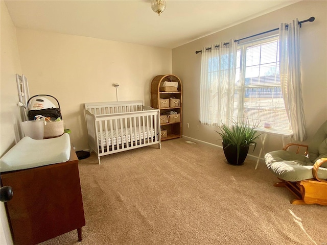 carpeted bedroom featuring a crib