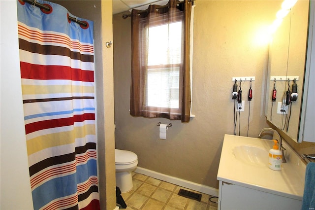 bathroom with vanity, curtained shower, and toilet