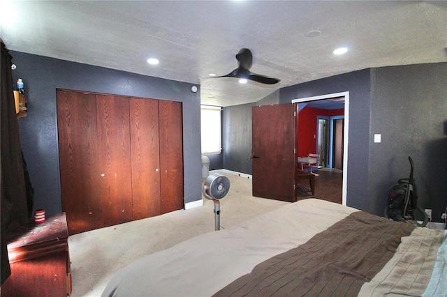 carpeted bedroom featuring ceiling fan and a closet