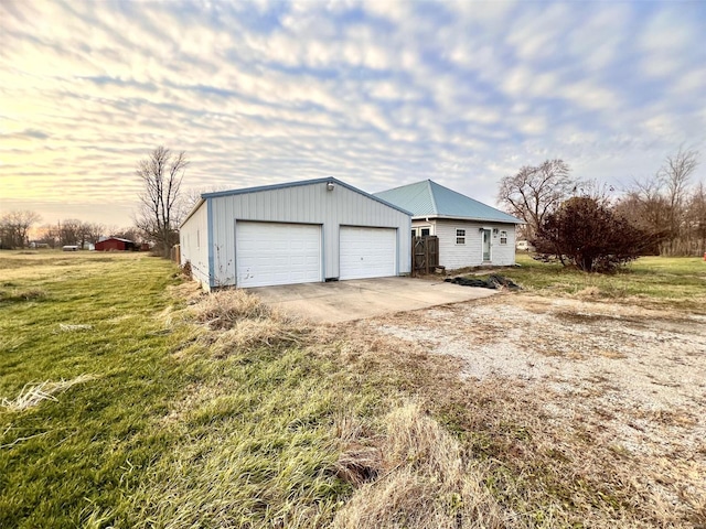 exterior space featuring a yard, an outbuilding, and a garage