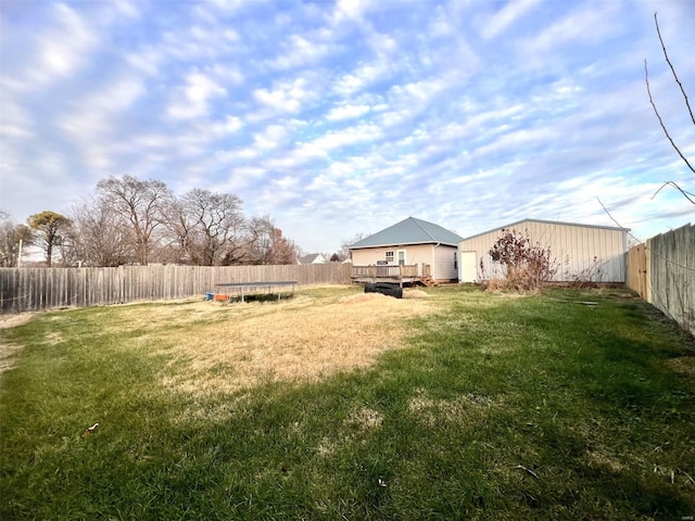 view of yard with a wooden deck and a trampoline