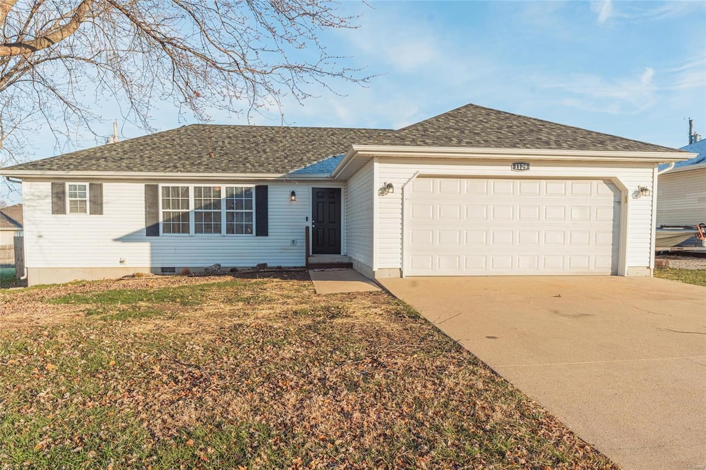 ranch-style home featuring a garage and a front lawn