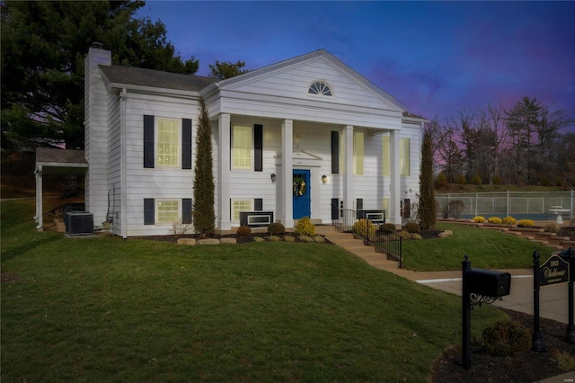 view of front of property with a lawn and central air condition unit