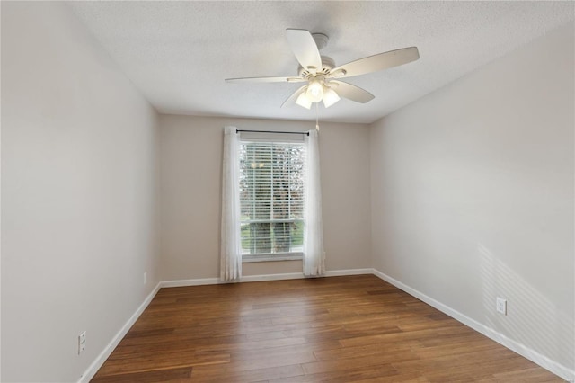 empty room with ceiling fan, wood-type flooring, and a textured ceiling