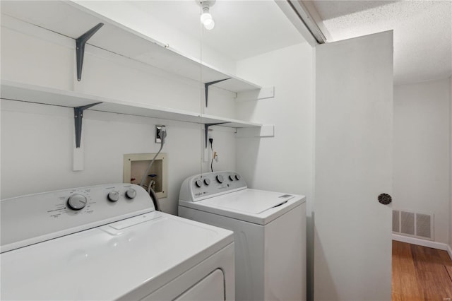 laundry room featuring hardwood / wood-style floors and washer and dryer