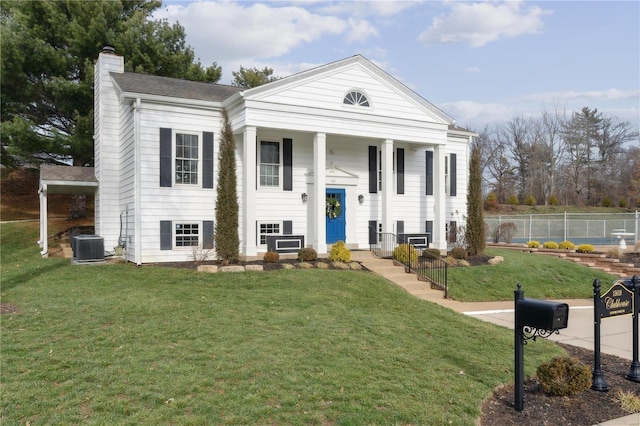 view of front of property with central air condition unit and a front yard