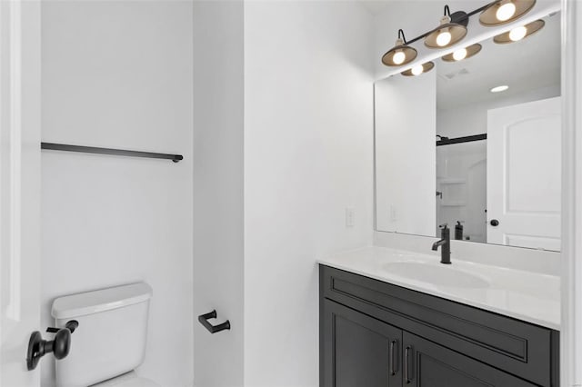 bathroom featuring a shower, vanity, and toilet