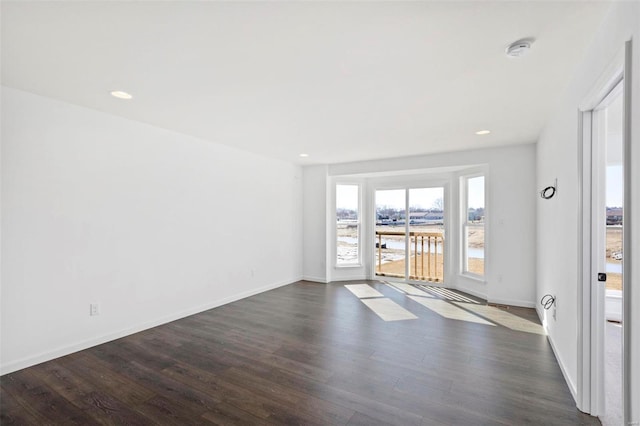 spare room featuring dark hardwood / wood-style flooring and a water view