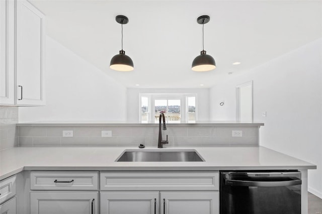 kitchen featuring wood-type flooring, black dishwasher, hanging light fixtures, and sink