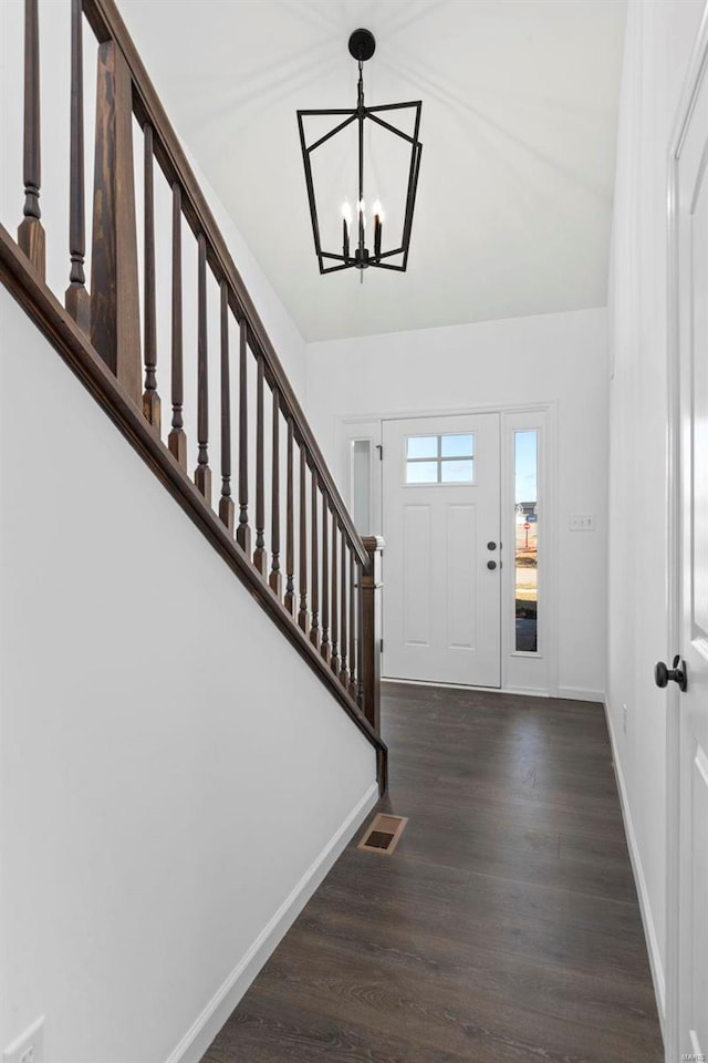 entrance foyer featuring dark wood-type flooring and a notable chandelier