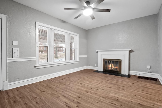 unfurnished living room featuring ceiling fan and wood-type flooring