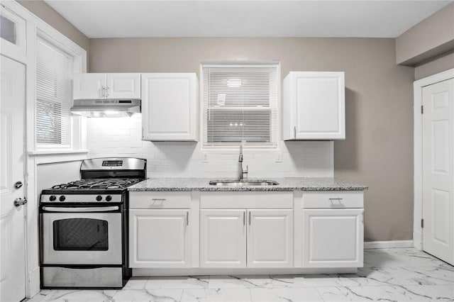 kitchen featuring white cabinets, gas stove, sink, and tasteful backsplash