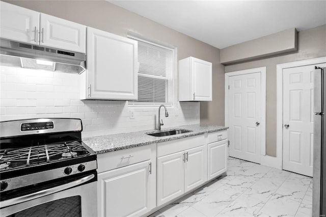 kitchen featuring appliances with stainless steel finishes, tasteful backsplash, light stone counters, sink, and white cabinets