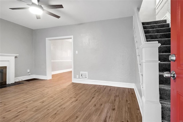 unfurnished living room featuring wood-type flooring and ceiling fan