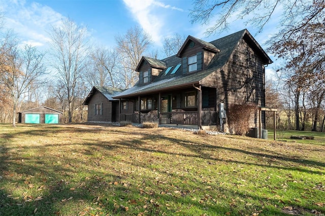 exterior space featuring a yard, an outbuilding, covered porch, and a garage