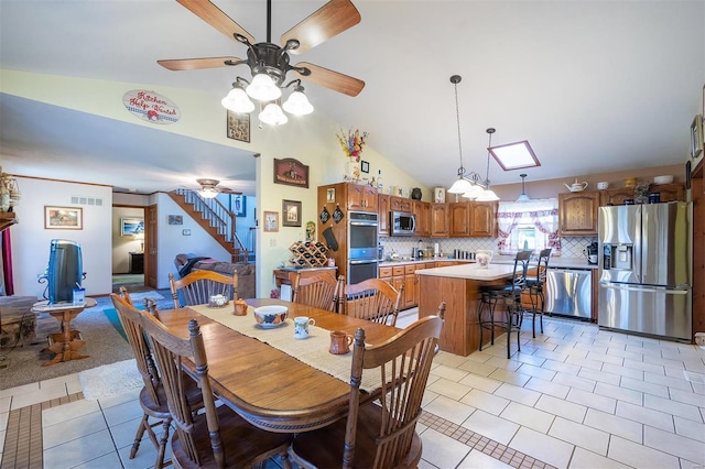 tiled dining room with ceiling fan and high vaulted ceiling