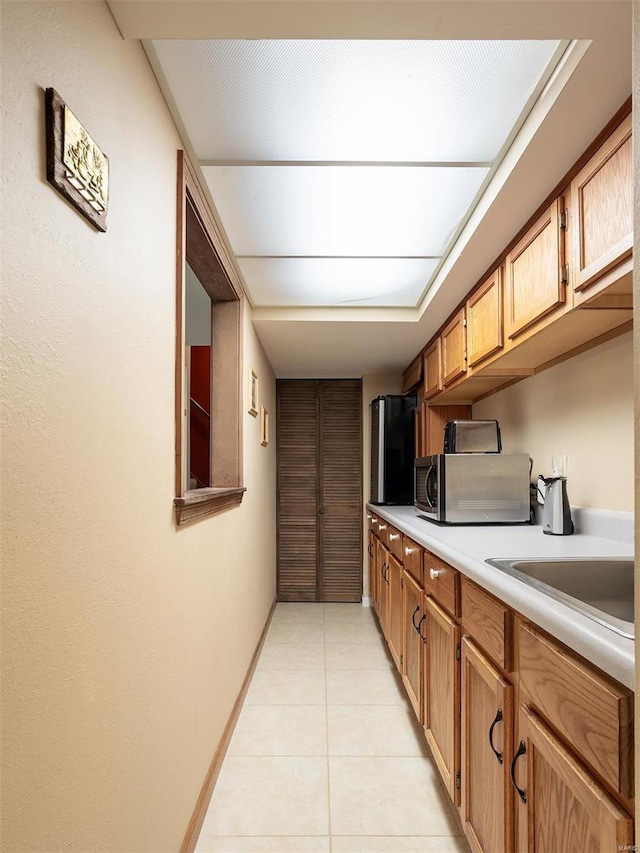 kitchen with light tile patterned floors and sink