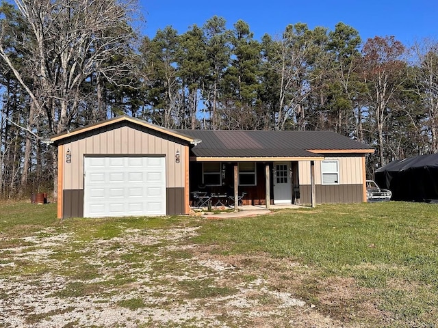 ranch-style home featuring a front lawn, covered porch, and a garage