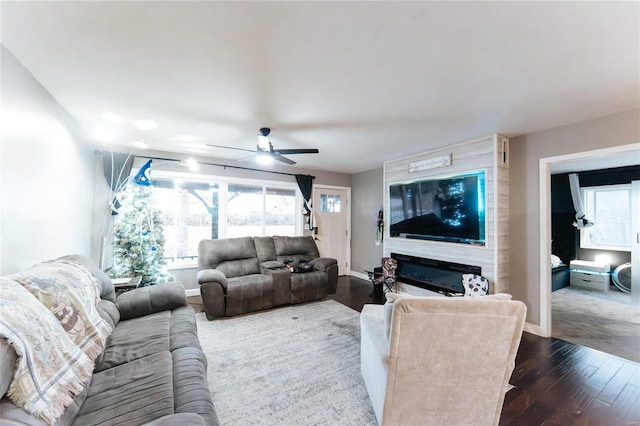 living room featuring ceiling fan and dark wood-type flooring