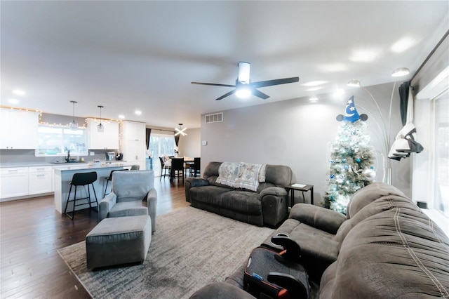 living room with ceiling fan and dark hardwood / wood-style flooring