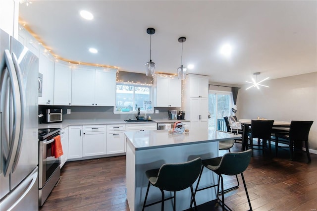 kitchen featuring dark hardwood / wood-style flooring, a healthy amount of sunlight, sink, and stainless steel appliances