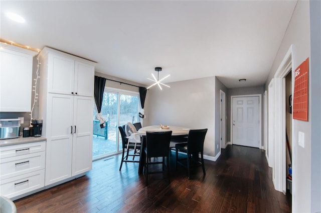 dining room with dark hardwood / wood-style flooring and an inviting chandelier