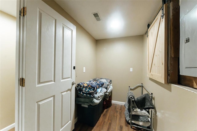 washroom with a barn door and dark hardwood / wood-style floors