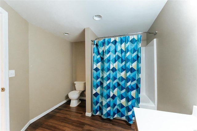 bathroom with hardwood / wood-style floors, shower / bath combination with curtain, and toilet