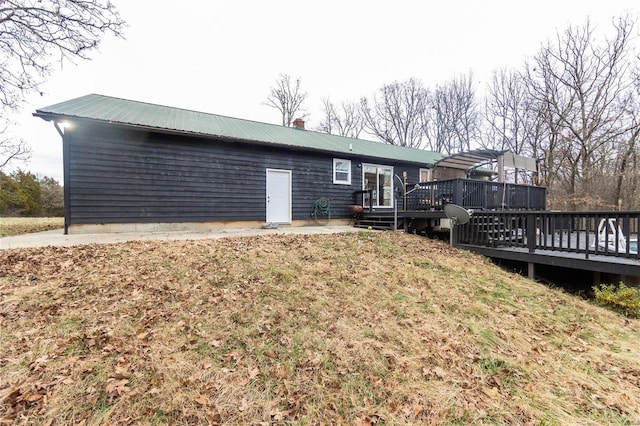 rear view of property with a lawn and a wooden deck