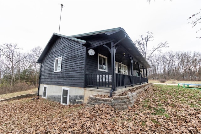 view of side of home featuring covered porch