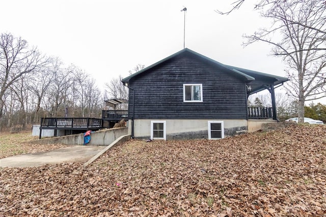 view of property exterior featuring a deck and a patio