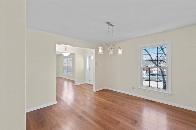 unfurnished dining area featuring hardwood / wood-style floors and a chandelier