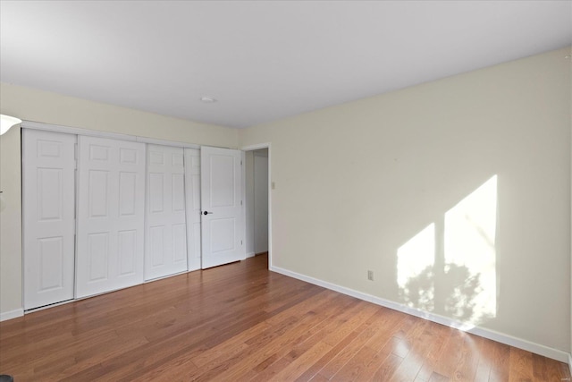 unfurnished bedroom with wood-type flooring and a closet