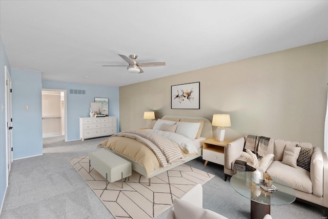 bedroom with light colored carpet, a spacious closet, and ceiling fan