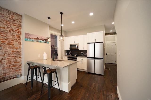 kitchen featuring white cabinetry, sink, kitchen peninsula, and stainless steel appliances